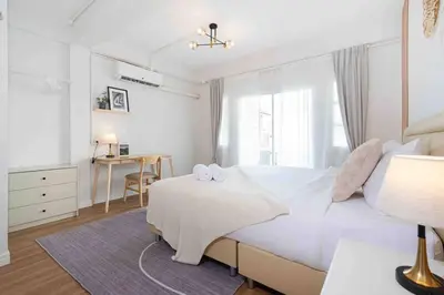 a bedroom with a large white bed and a desk at Private 4BR Model Home center Patong in Patong Beach