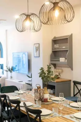 a dining room table with chairs and two chandeliers at Private 4BR Model Home center Patong in Patong Beach