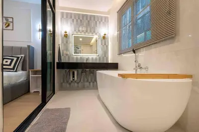 a bathroom with a large white tub and a sink at Private 4BR Model Home center Patong in Patong Beach