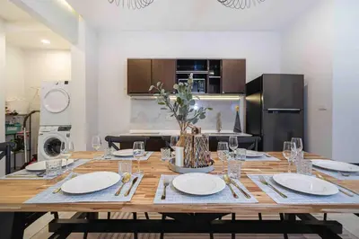 a large wooden table with plates and wine glasses at Private 4BR Model Home center Patong in Patong Beach
