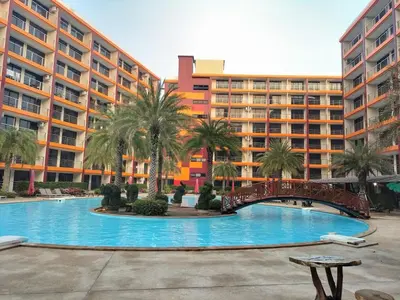 a large swimming pool with a bridge in front of a building at Heavenly place 777 on Mai Khao in Ban Mai Salae