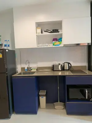 a kitchen with a blue counter and a sink and a refrigerator at The Base Central Phuket in Phuket Town