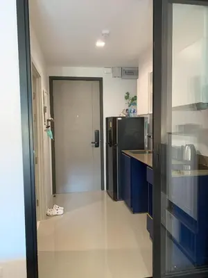 a kitchen with blue cabinets and a black refrigerator at The Base Central Phuket in Phuket Town