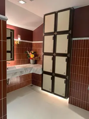 a bathroom with brown tiled walls and a large door at The Base Central Phuket in Phuket Town