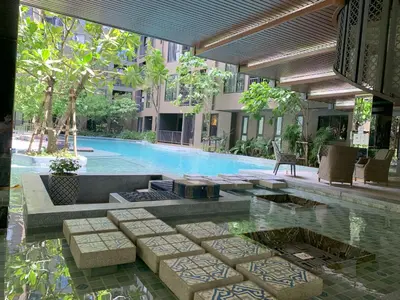 a swimming pool next to a building with a swimming pool at The Base Central Phuket in Phuket Town