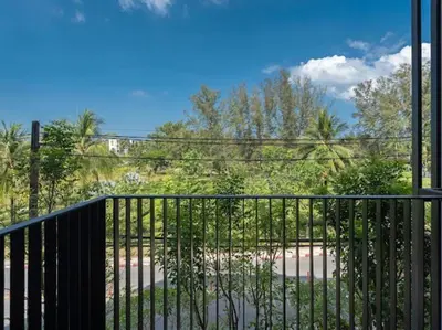 a balcony with a black fence and trees at Bangtao , Laguna , 5 minutes from the bench, 2 bedroom in Ban Thalat Choeng Thale