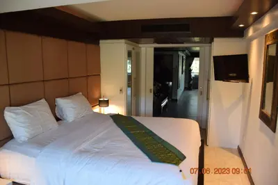 a bedroom with a white bed with a green blanket at KALIM RESIDENCE UNIT 133 VUE MER in Patong Beach