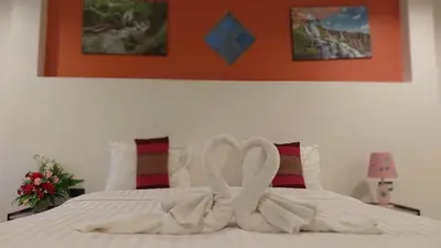 two swansrendered to look like they are kissing on a bed at Benetti house in Patong Beach