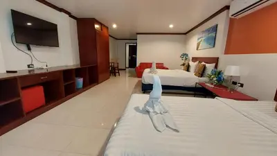 a hotel room with two beds and a flat screen tv at Benetti house in Patong Beach