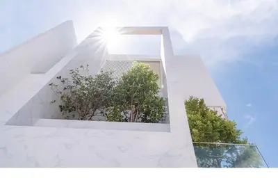 a white building with trees in the window at The Residence by Andaman Phuket in Ban Mut Dok Khao