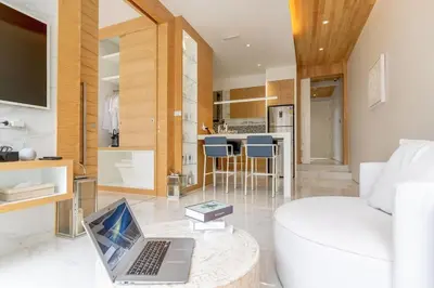 a living room with a laptop on a glass table at The Residence by Andaman Phuket in Ban Mut Dok Khao