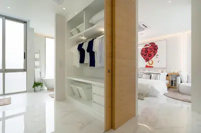 a white room with a bed and a bathroom at The Residence by Andaman Phuket in Ban Mut Dok Khao