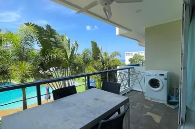 a balcony with a washing machine and a pool at Karon Butterfly Condominium Brandnew 68m2 apartment, seaview, pool access, 500m to beach in Karon Beach