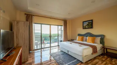 a bedroom with a bed and a large window at So View Phuket Resort in Ban Sam Kong