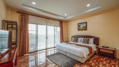 a bedroom with a large bed and a large window at So View Phuket Resort in Ban Sam Kong