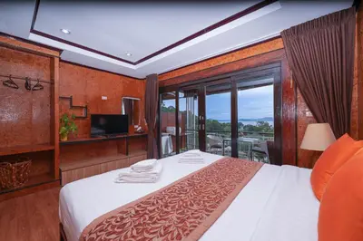 a hotel room with a bed with a balcony at So View Phuket Resort in Ban Sam Kong