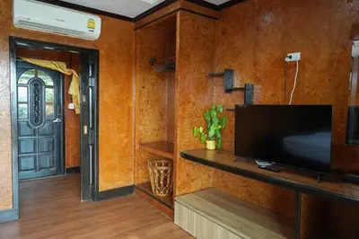 a living room with a flat screen tv and a door at So View Phuket Resort in Ban Sam Kong
