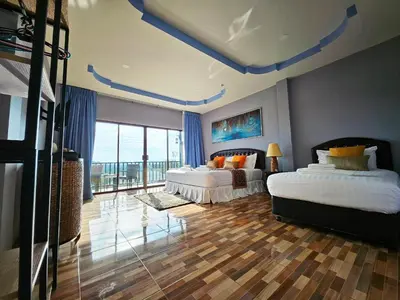 a bedroom with two beds and a large window at So View Phuket Resort in Ban Sam Kong