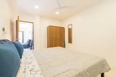 a bedroom with a bed and a blue couch at Chonlada Pool Villa - 6-BR - Kamala Beach in Phuket Town