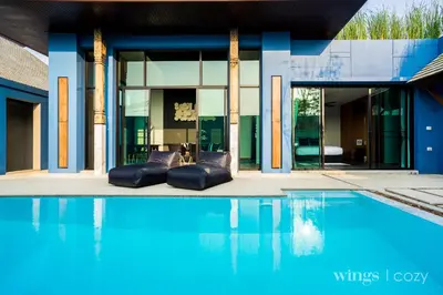 a house with a swimming pool in front of a house at Wings Phuket Villa by Two Villas HOLIDAY in Bang Tao Beach