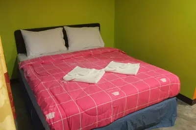 a pink bed with two white towels on it at Rc Guest House in Phi Phi Don
