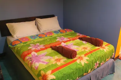 a large bed with a colorful blanket with flowers on it at Rc Guest House in Phi Phi Don