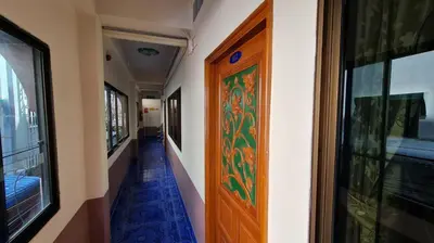 a hallway with a wooden door in a building at Vech Guesthouse Patong in Patong Beach