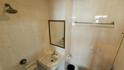 a bathroom with a sink and a toilet and a mirror at Vech Guesthouse Patong in Patong Beach