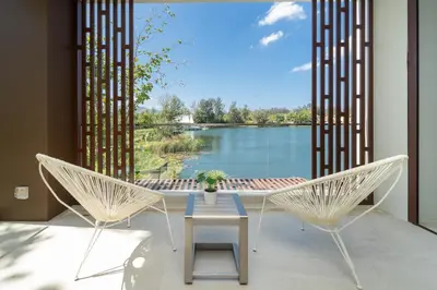 a patio with two chairs and a table and a view of a lake at Laguna Angsana Apartments Lake View in Bang Tao Beach