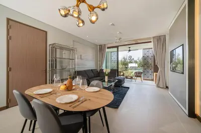 a dining room table and chairs in a living room at Laguna Angsana Apartments Lake View in Bang Tao Beach