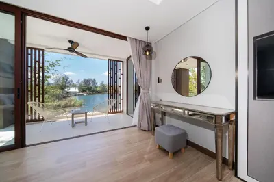 a home office with a mirror and a desk and a balcony at Laguna Angsana Apartments Lake View in Bang Tao Beach