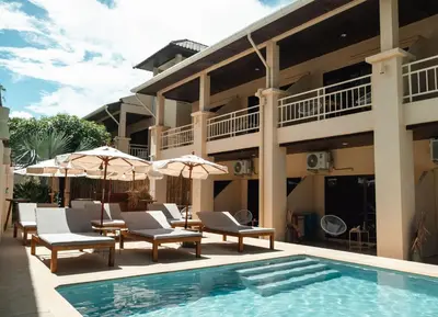 a resort with a pool and chairs and umbrellas at Casa Solana Patong in Patong Beach