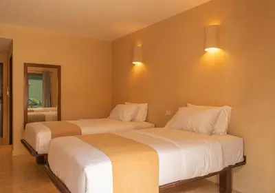 two beds in a bedroom with two lights on the wall at Casa Solana Patong in Patong Beach