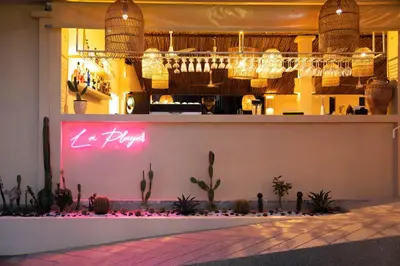 a restaurant with a bar with a pink neon sign at Casa Solana Patong in Patong Beach