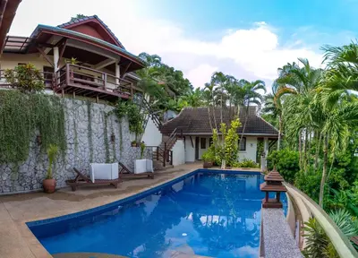 a villa with a swimming pool and a house at Baiyok Villa seaview and edge pool in Patong Beach