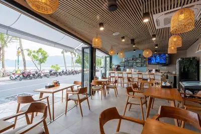 a restaurant with tables and chairs and a street at Patong Signature Boutique Hotel in Patong Beach