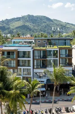 a building with palm trees in front of it at Patong Signature Boutique Hotel in Patong Beach