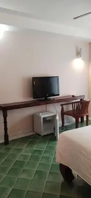 a room with a tv and a desk and a bed at Rendez Vous Hotel in Patong Beach