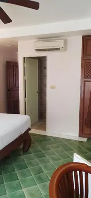 a bedroom with a bed and a green floor at Rendez Vous Hotel in Patong Beach