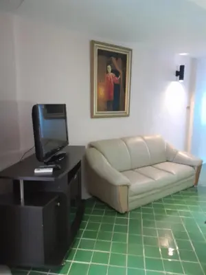 a living room with a couch and a tv at Rendez Vous Hotel in Patong Beach