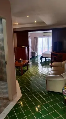 a room with a green tiled floor and a bedroom at Rendez Vous Hotel in Patong Beach
