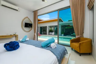 a bedroom with a bed and a swimming pool at Villa Mimosa 1, Luxury 4BR with Private Pool/Rawai in Phuket Town
