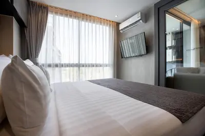 a bedroom with a large white bed with a window at Tropics Kamala Pool View Residence CTG B704 in Kamala Beach