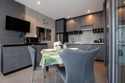 a kitchen with a table and chairs in a kitchen at tropics Kamala Deluxe Pool View Apartment CTG P602 in Kamala Beach