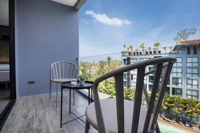 a balcony with two chairs and a view of a building at tropics Kamala Deluxe Pool View Apartment CTG P602 in Kamala Beach