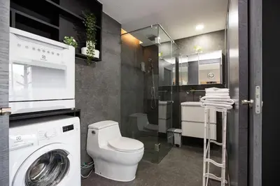 a bathroom with a toilet and a washing machine at tropics Kamala Deluxe Pool View Apartment CTG P602 in Kamala Beach