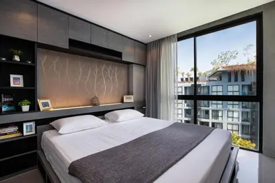 a bedroom with a large bed and a large window at tropics Kamala Deluxe Pool View Apartment CTG P602 in Kamala Beach