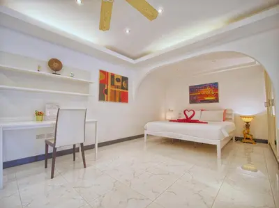 a bedroom with a bed and a table and a chair at Serenity Lakeside Resort in Kathu