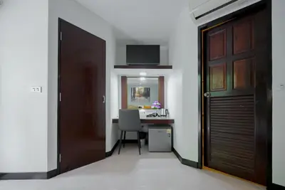 a room with a door and a desk with a chair at Tri's Miracle Kata Beach Side in Kata Beach