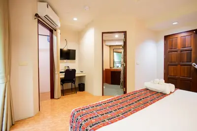 a hotel room with a bed and a desk at Tri's Miracle Kata Beach Side in Kata Beach